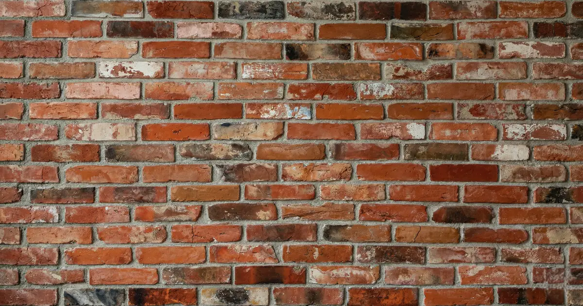 Płytki z cegły ułożone z tradycyjną, szeroką szarą fugą o grubości około 15 milimetrów.